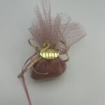 Μια κομψή μπομπονιέρα για βάπτιση, με ροζ τούλι και χρυσές λεπτομέρειες, στολισμένη με ένα χρυσό κύκνο.