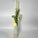 Λευκή πασχαλινή λαμπάδα διακοσμημένη με σπάγγο, γυαλιστερή κορδέλα, φυτικά στοιχεία και κίτρινα διακοσμητικά.